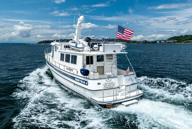 Slide: The Image of 2007 Nordic Tug 54 cruising on open water under a clear blue sky. - 4