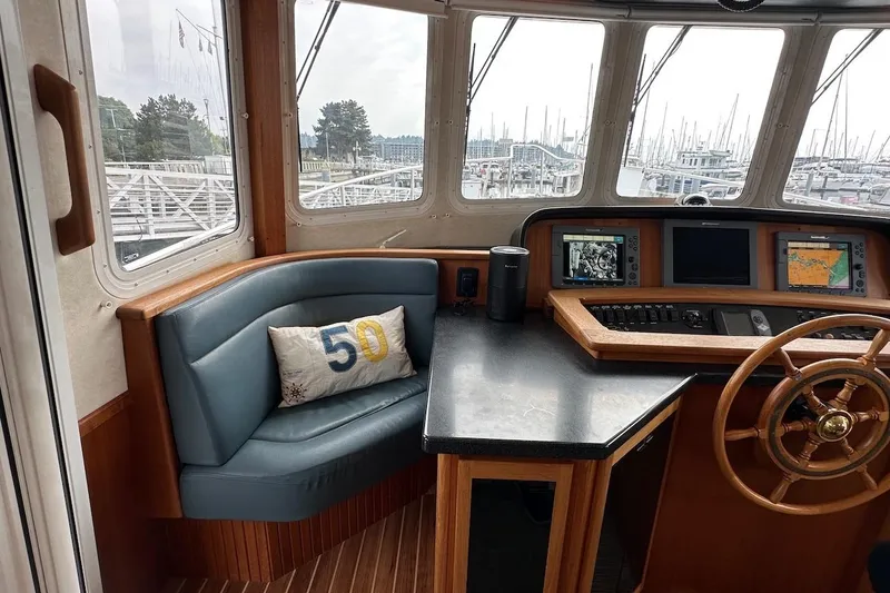 Slide: The Image of Cozy helm of 2007 Nordic Tug 54 with navigation screens and cushioned seating. - 46