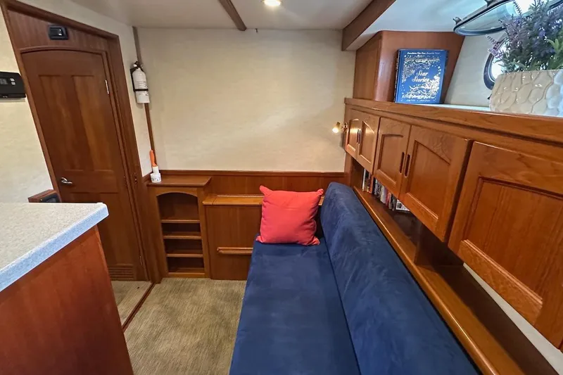 Slide: The Image of Cozy interior of 2007 Nordic Tug 54 with blue sofa, wooden cabinets, and decorative elements. - 51