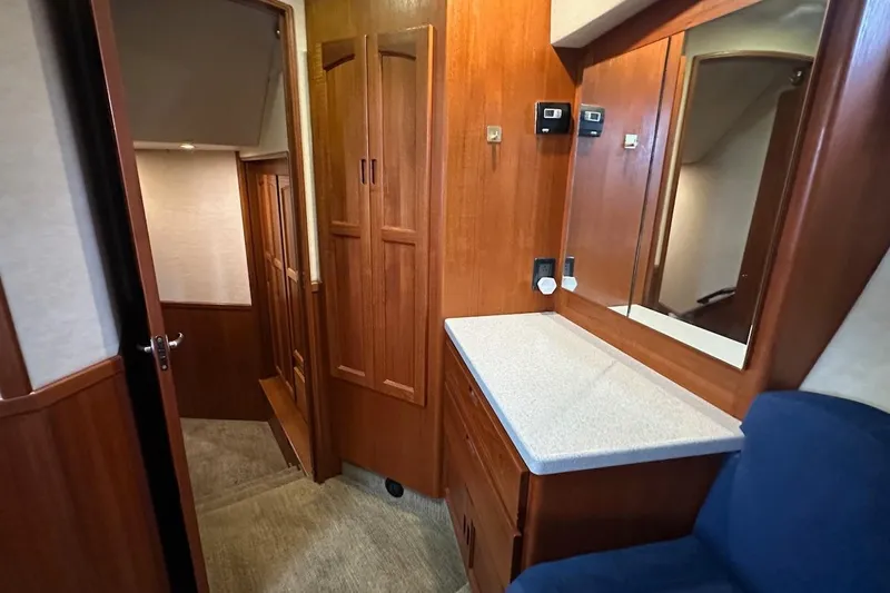 Slide: The Image of Interior of 2007 Nordic Tug 54, featuring wooden cabinetry and a mirror above a countertop. - 65