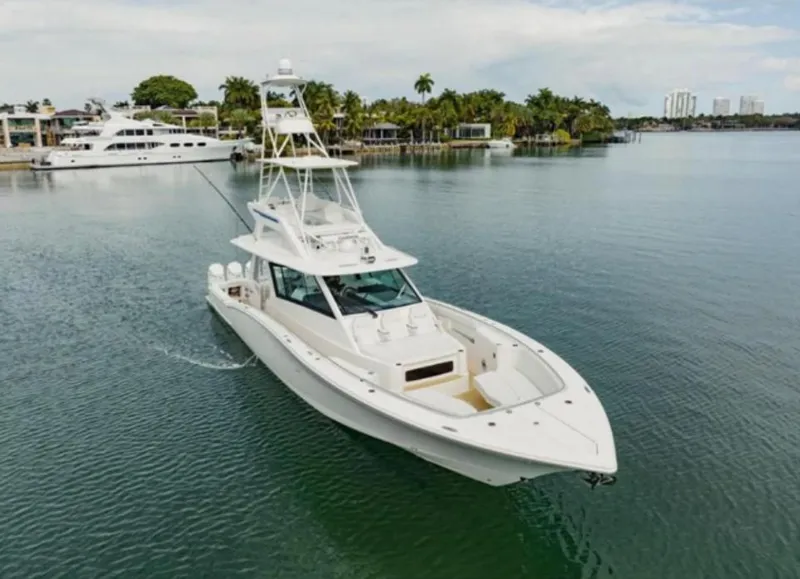 Slide: The Image of 2021 Scout 530 LXF luxury yacht cruising on calm waters near a marina. - 2
