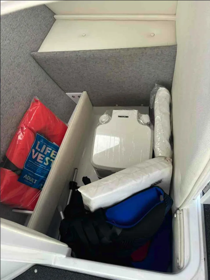 Slide: The Image of Storage compartment in 2021 Cobalt R5 boat with life vest and portable toilet. - 18