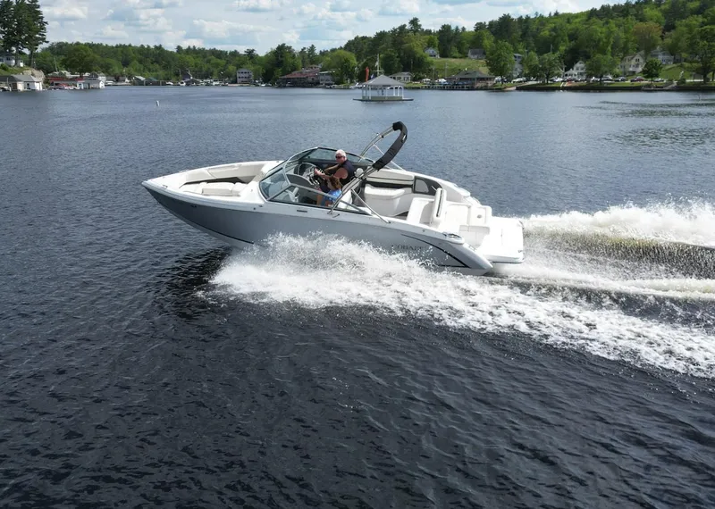 Slide: The Image of 2021 Cobalt R5 speedboat cruising on a scenic lake with lush green shoreline. - 24
