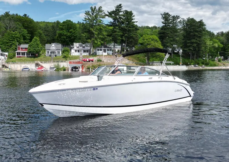 Slide: The Image of 2021 Cobalt R5 boat on a scenic lake with houses and trees in the background. - 26