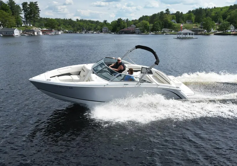 Slide: The Image of 2021 Cobalt R5 boat cruising on a scenic lake with lush green surroundings. - 3