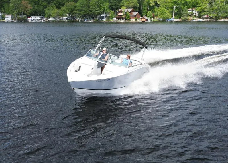 Slide: The Image of 2021 Cobalt R5 boat cruising on a lake with lush green shoreline. - 31