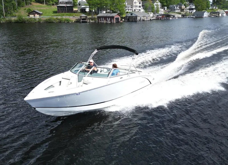 Slide: The Image of 2021 Cobalt R5 boat cruising on a lake with scenic shoreline houses. - 32