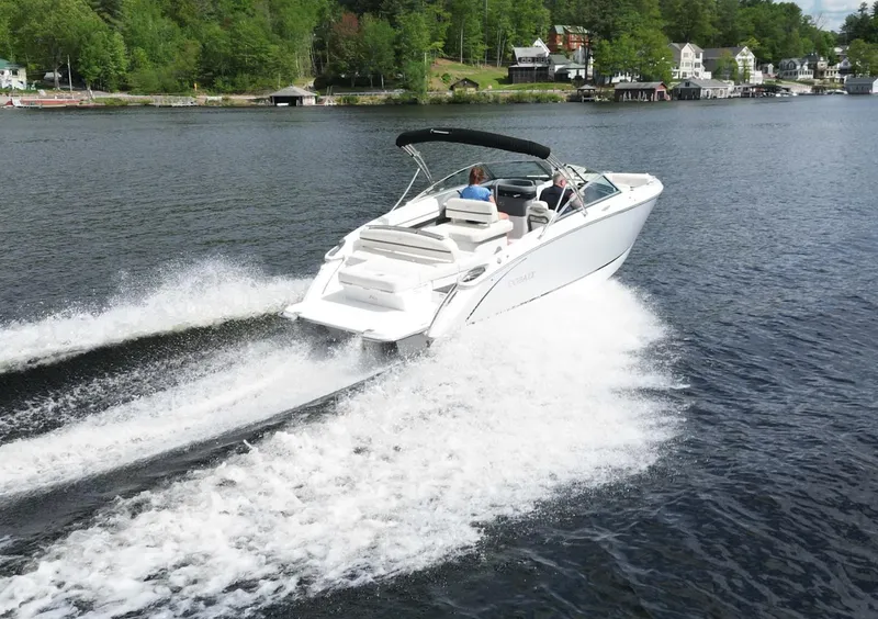 Slide: The Image of 2021 Cobalt R5 boat cruising on a lake with lush green shoreline. - 4