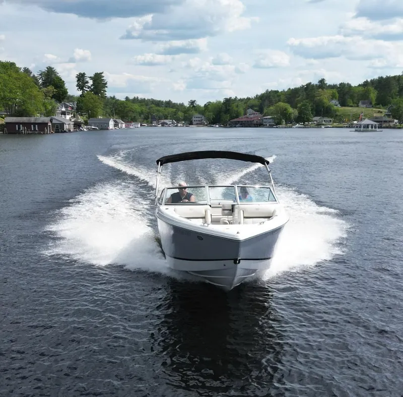 Slide: The Image of 2021 Cobalt R5 boat cruising on a scenic lake with lush green surroundings. - 5
