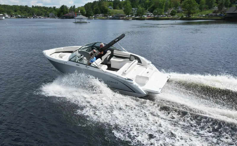 Slide: The Image of 2021 Cobalt R5 boat cruising on a lake with lush green shoreline. - 6
