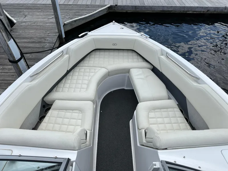 Slide: The Image of 2021 Cobalt R5 boat with white cushioned seating, docked by the water. - 8