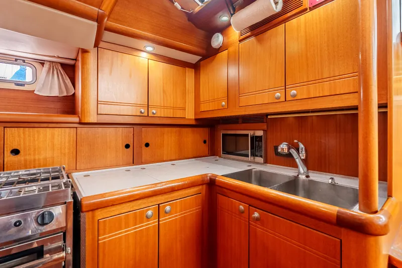 Slide: The Image of 1997 Farr 60 Pilot House yacht kitchen with wooden cabinets and modern appliances. - 31