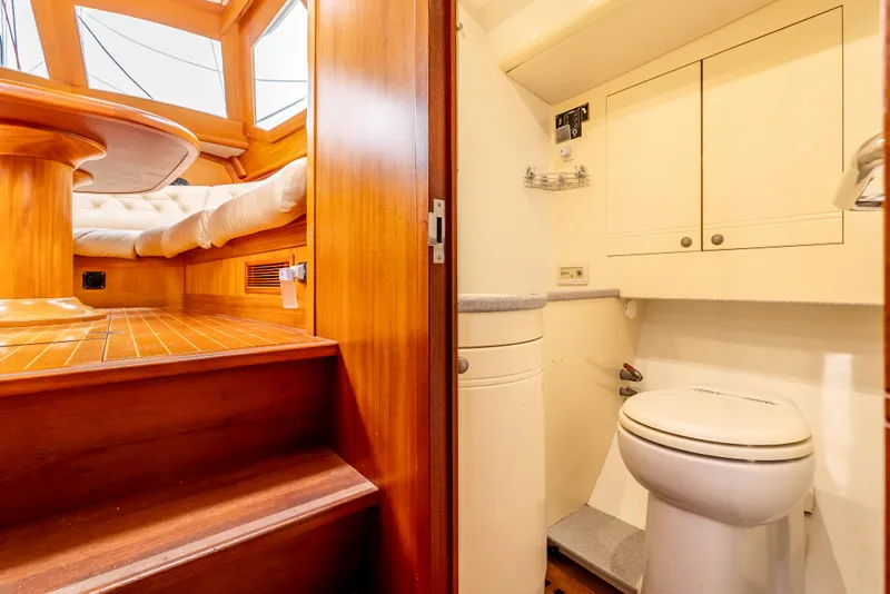 Slide: The Image of Interior of 1997 Farr 60 Pilot House yacht, featuring wooden stairs and compact bathroom. - 41
