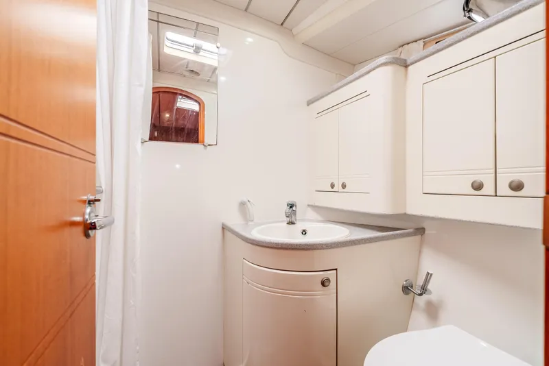 Slide: The Image of Bathroom interior of 1997 Farr 60 Pilot House yacht, featuring white cabinetry and sink. - 47