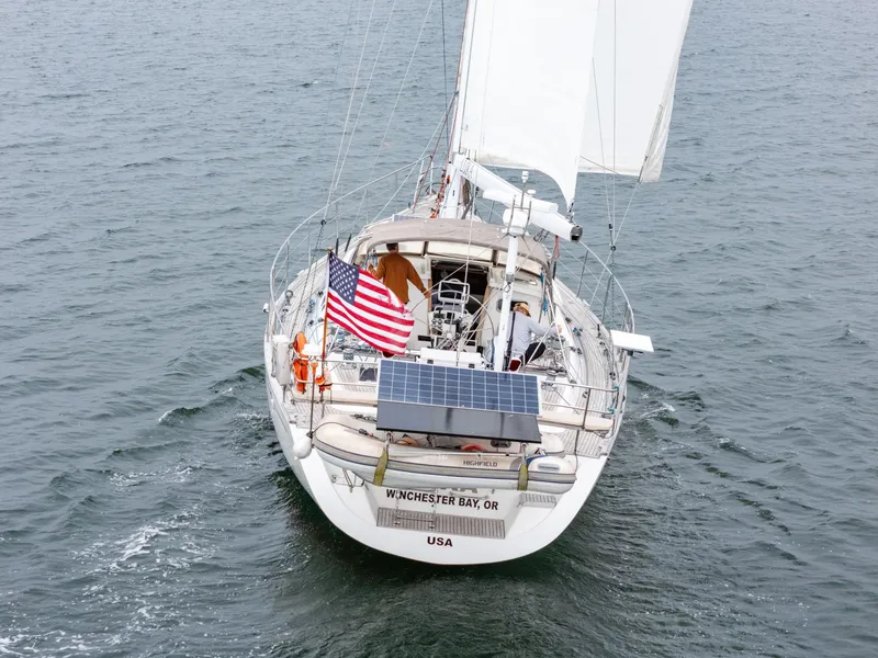 Slide: The Image of Sailing yacht Farr 60 Pilot House 1997 with American flag on open water. - 6