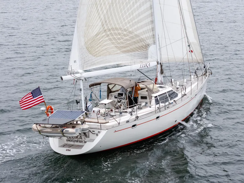 Slide: The Image of Sailing yacht Farr 60 Pilot House 1997 on open water, featuring American flag and solar panel. - 7