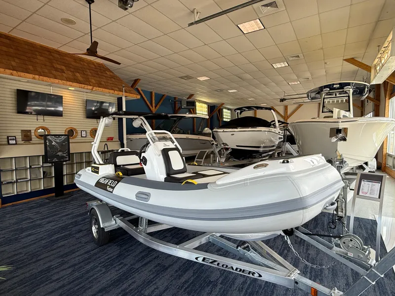 The Image of 2025 Highfield Velox 420 boat displayed in a showroom on a trailer. - 1