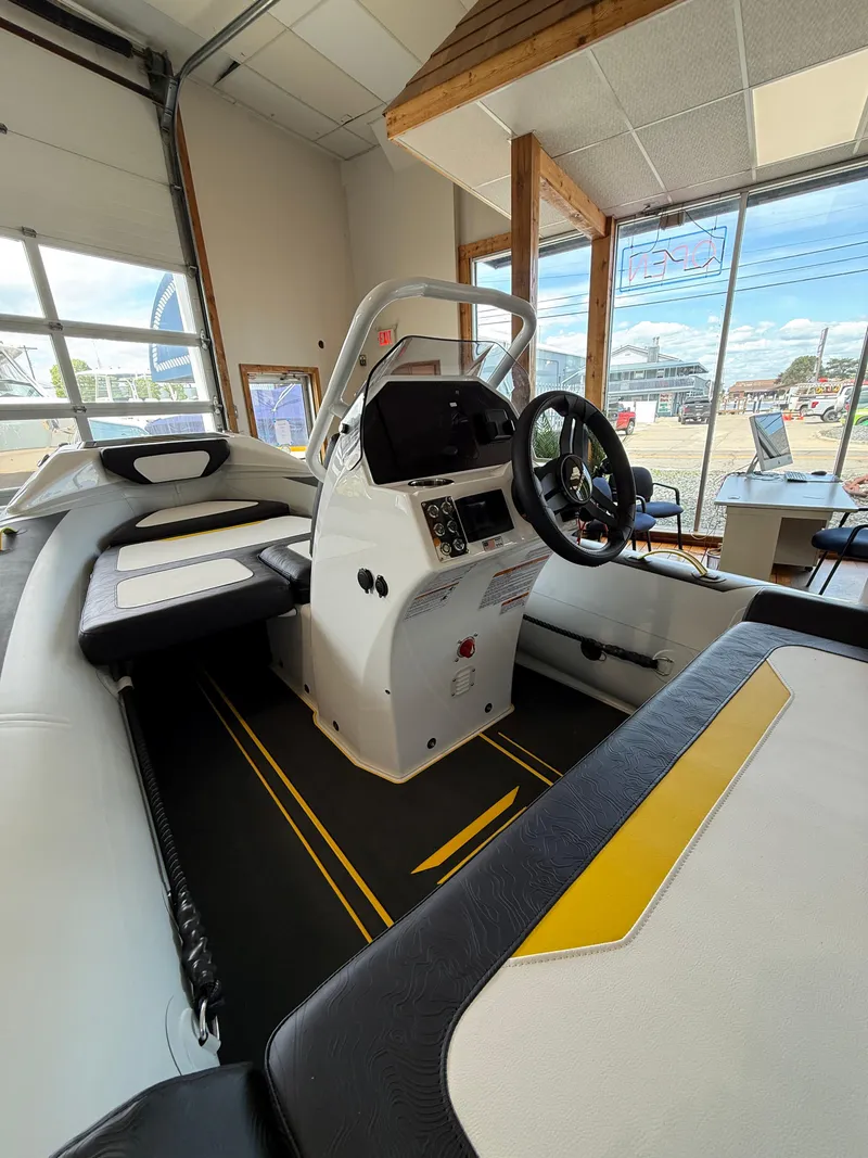 Slide: The Image of 2025 Highfield Velox 420 boat interior with modern console and seating in showroom. - 5