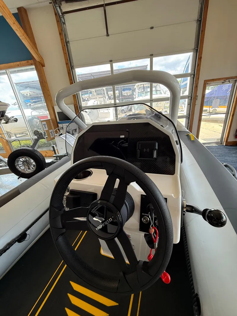 Slide: The Image of 2025 Highfield Velox 420 boat interior with steering wheel and dashboard in showroom. - 8