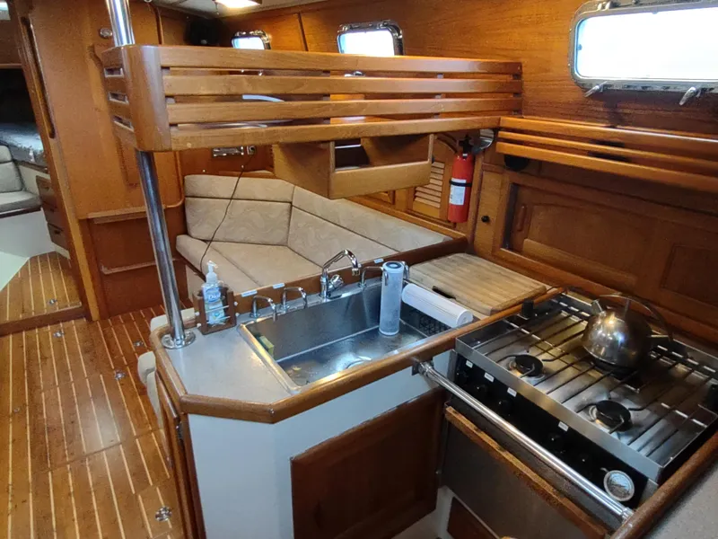 Slide: The Image of Interior of 1997 Pacific Seacraft 37 sailboat with wooden cabinetry and compact kitchen. - 26