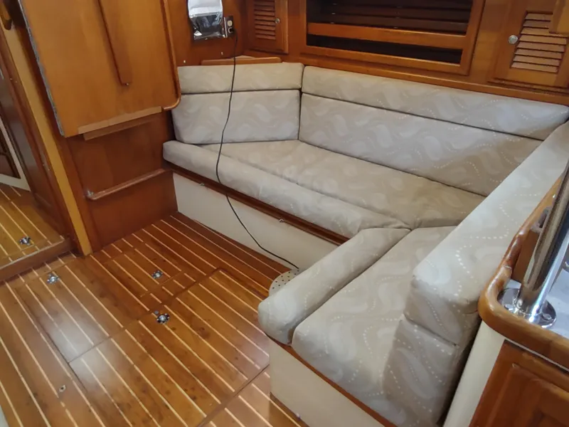 Slide: The Image of Interior of 1997 Pacific Seacraft 37 sailboat with wooden flooring and cushioned seating. - 34