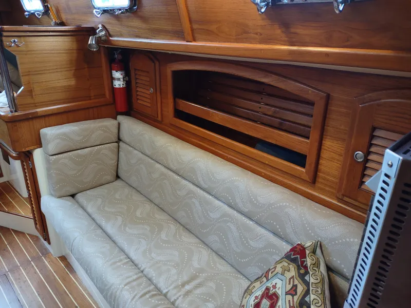Slide: The Image of Cozy interior of 1997 Pacific Seacraft 37 sailboat with wooden accents and cushioned seating. - 42