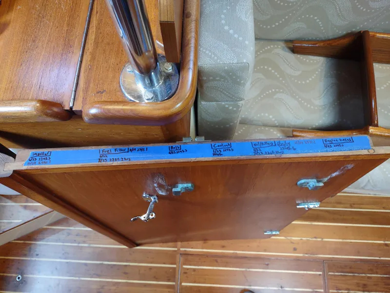 Slide: The Image of Interior of 1997 Pacific Seacraft 37 showing wooden cabinetry with handwritten notes on blue tape. - 48