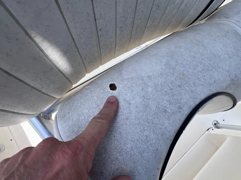 Slide: The Image of Finger pointing at a hole in the 2005 Hydra-Sports Vector 2400 CC boat surface. - 17