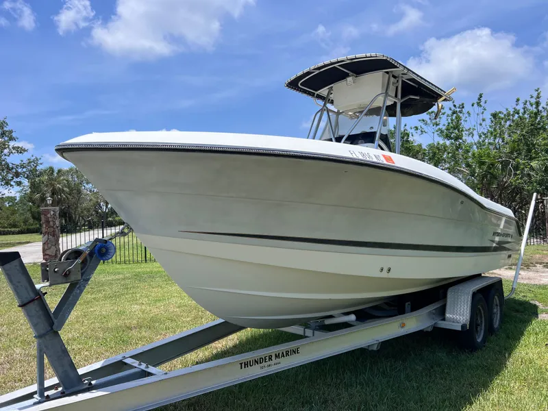 Slide: The Image of 2005 Hydra-Sports Vector 2400 CC boat on trailer, parked on grass under blue sky. - 2