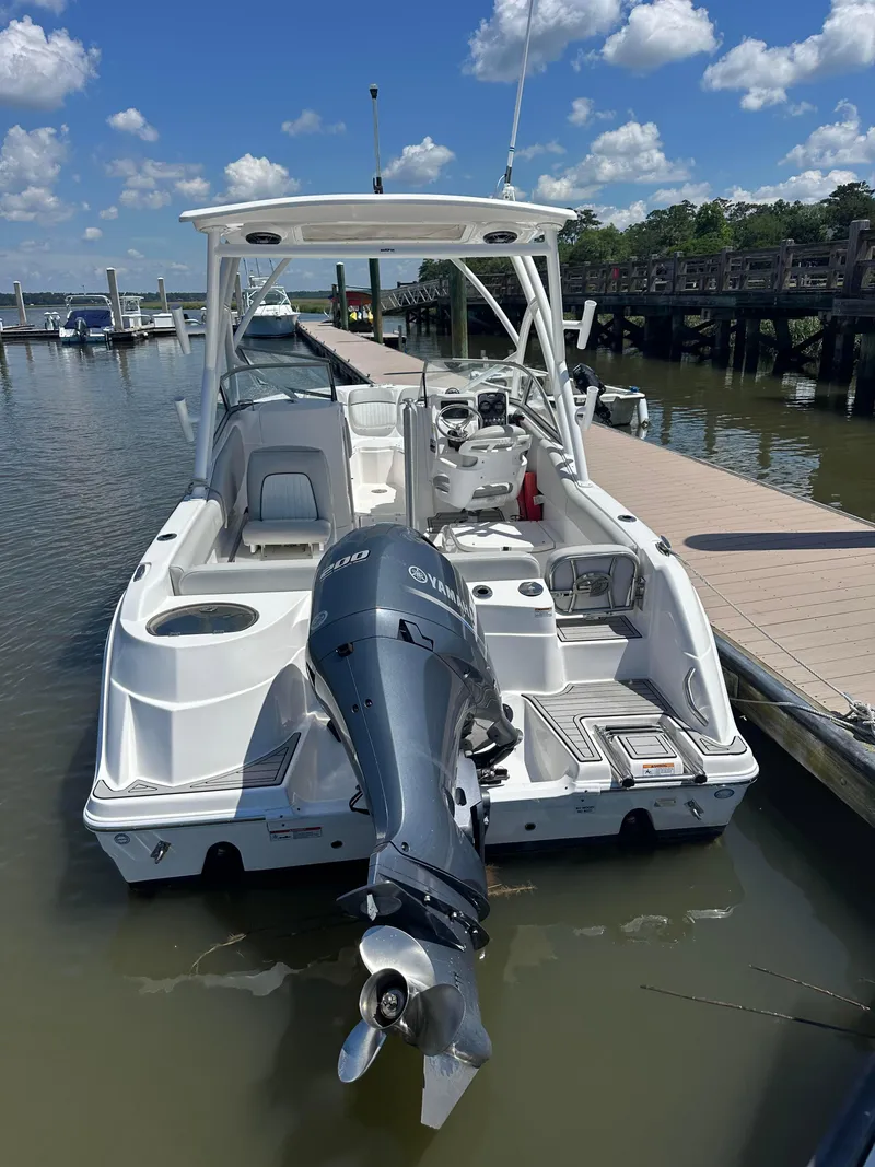 Slide: The Image of 2024 Sea Fox 226 Traveler boat docked, featuring a powerful outboard motor and spacious seating. - 14