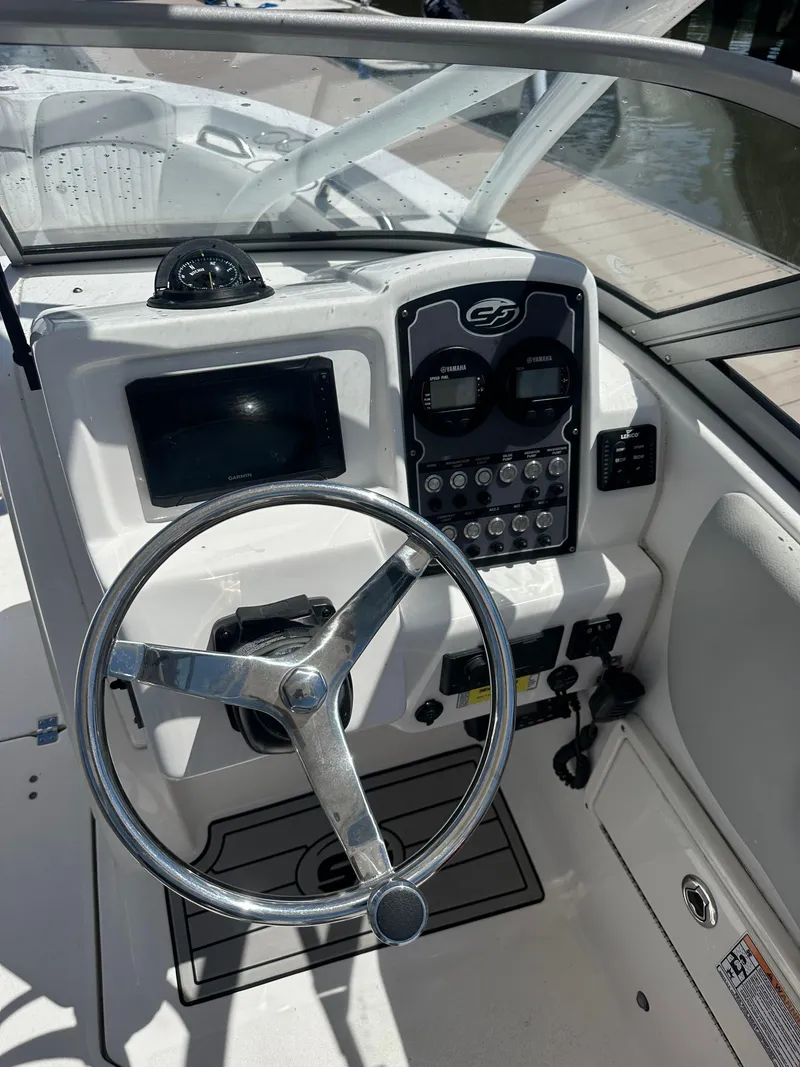 Slide: The Image of 2024 Sea Fox 226 Traveler boat dashboard with steering wheel and control panel. - 9