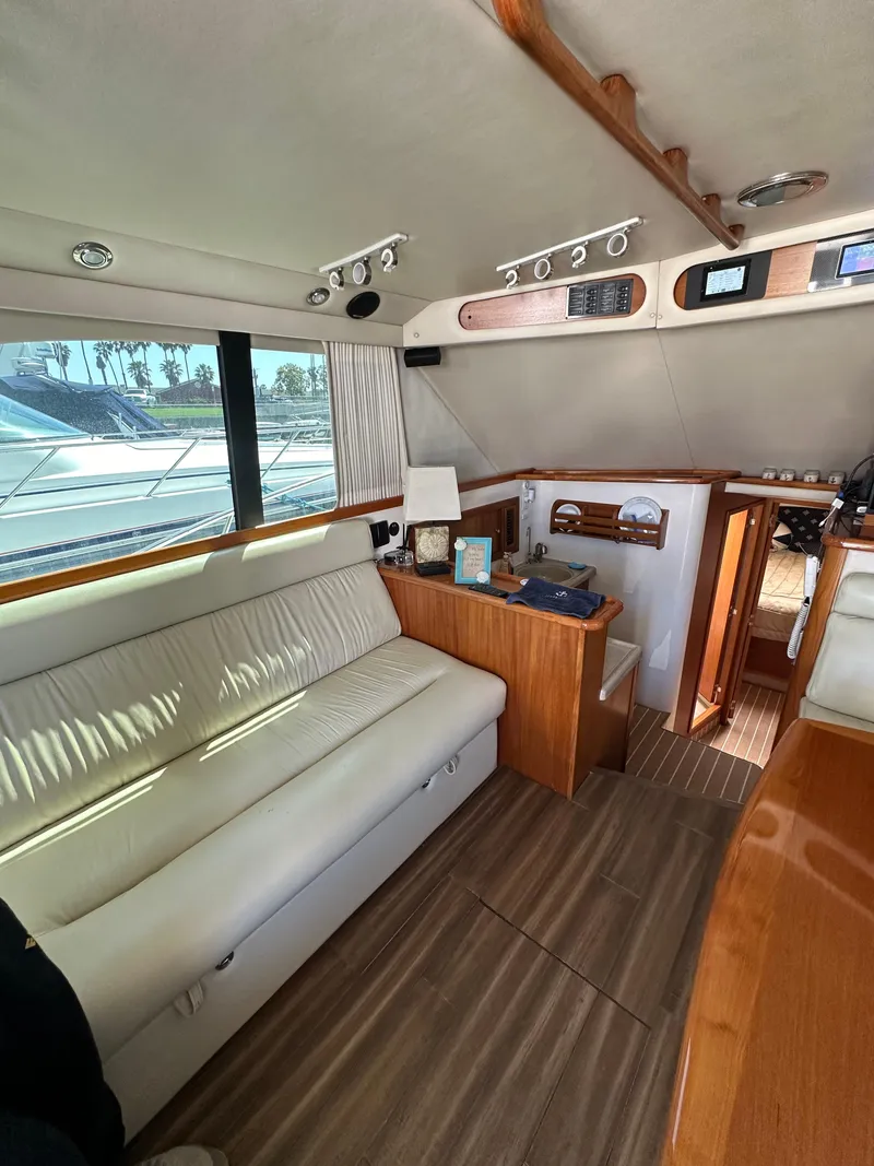 Slide: The Image of Interior of 2003 Riviera 37 Flybridge yacht with white seating and wooden accents. - 14