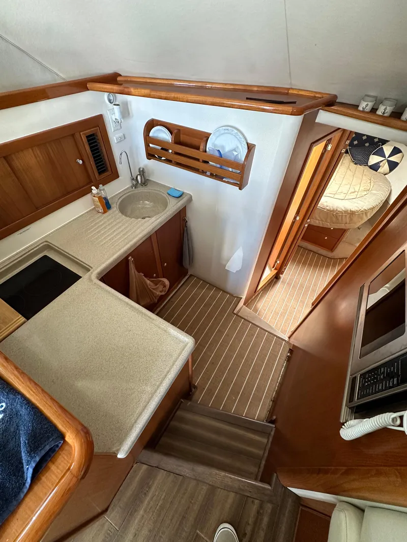Slide: The Image of Interior of 2003 Riviera 37 Flybridge yacht with kitchen and cozy bedroom. - 16