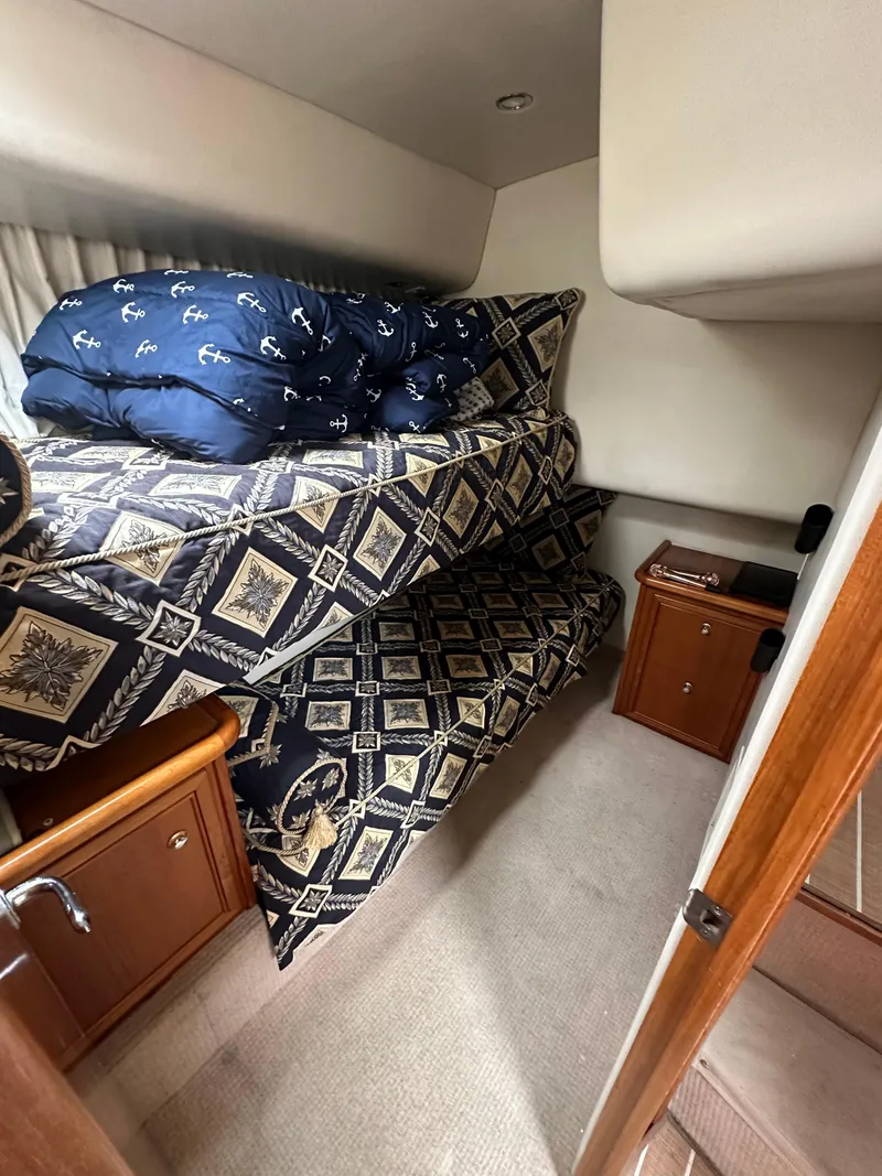 Slide: The Image of Interior cabin of 2003 Riviera 37 Flybridge with patterned bedding and wooden cabinets. - 18