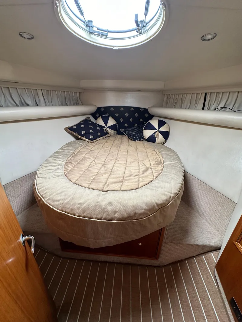 Slide: The Image of 2003 Riviera 37 Flybridge cabin with cozy bed and nautical-themed pillows. - 20