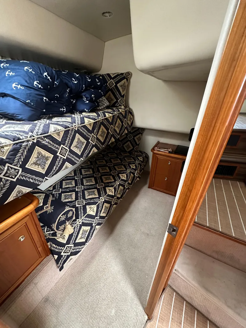 Slide: The Image of Interior of 2003 Riviera 37 Flybridge with bunk beds and nautical-themed bedding. - 23
