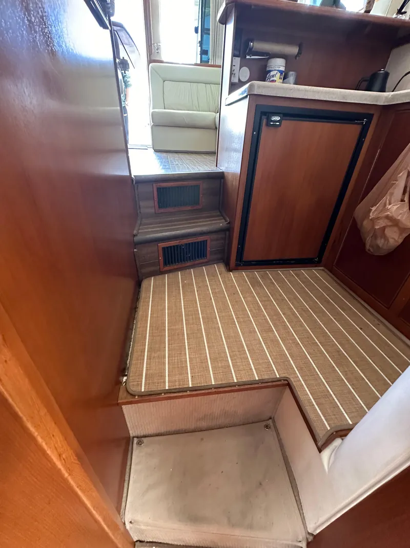 Slide: The Image of Interior of 2003 Riviera 37 Flybridge yacht with wooden cabinetry and compact kitchen area. - 24