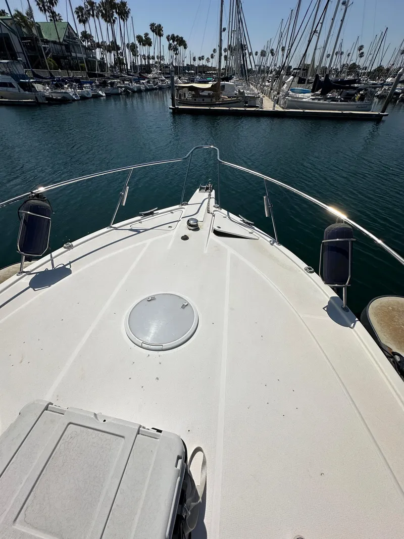 Slide: The Image of 2003 Riviera 37 Flybridge yacht docked in a marina with sailboats. - 26