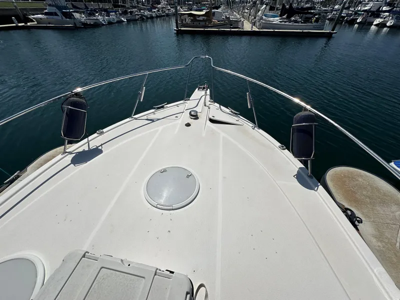 Slide: The Image of Bow view of 2003 Riviera 37 Flybridge yacht docked in marina. - 27