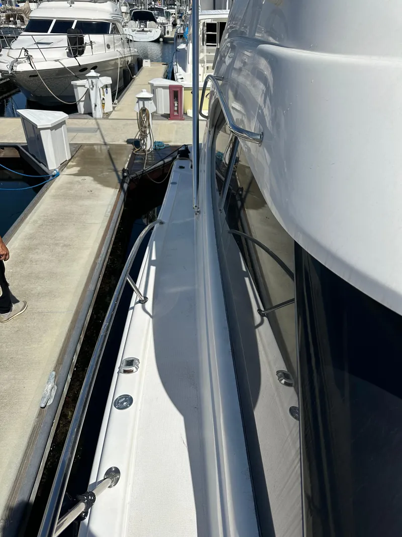 Slide: The Image of 2003 Riviera 37 Flybridge yacht docked at marina, side view. - 31