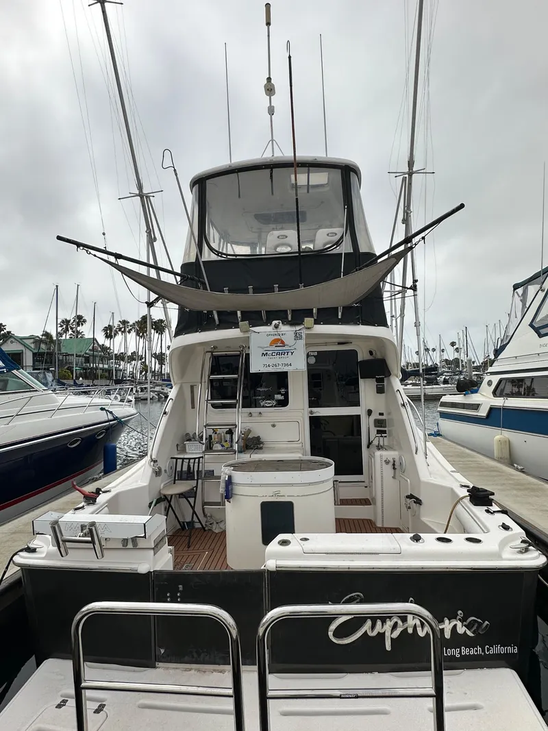 Slide: The Image of 2003 Riviera 37 Flybridge yacht docked in marina, rear view. - 40
