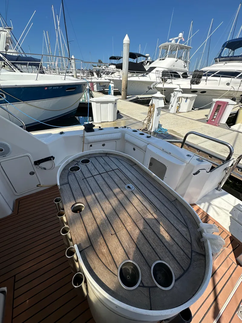 Slide: The Image of 2003 Riviera 37 Flybridge yacht with wooden deck at marina. - 8