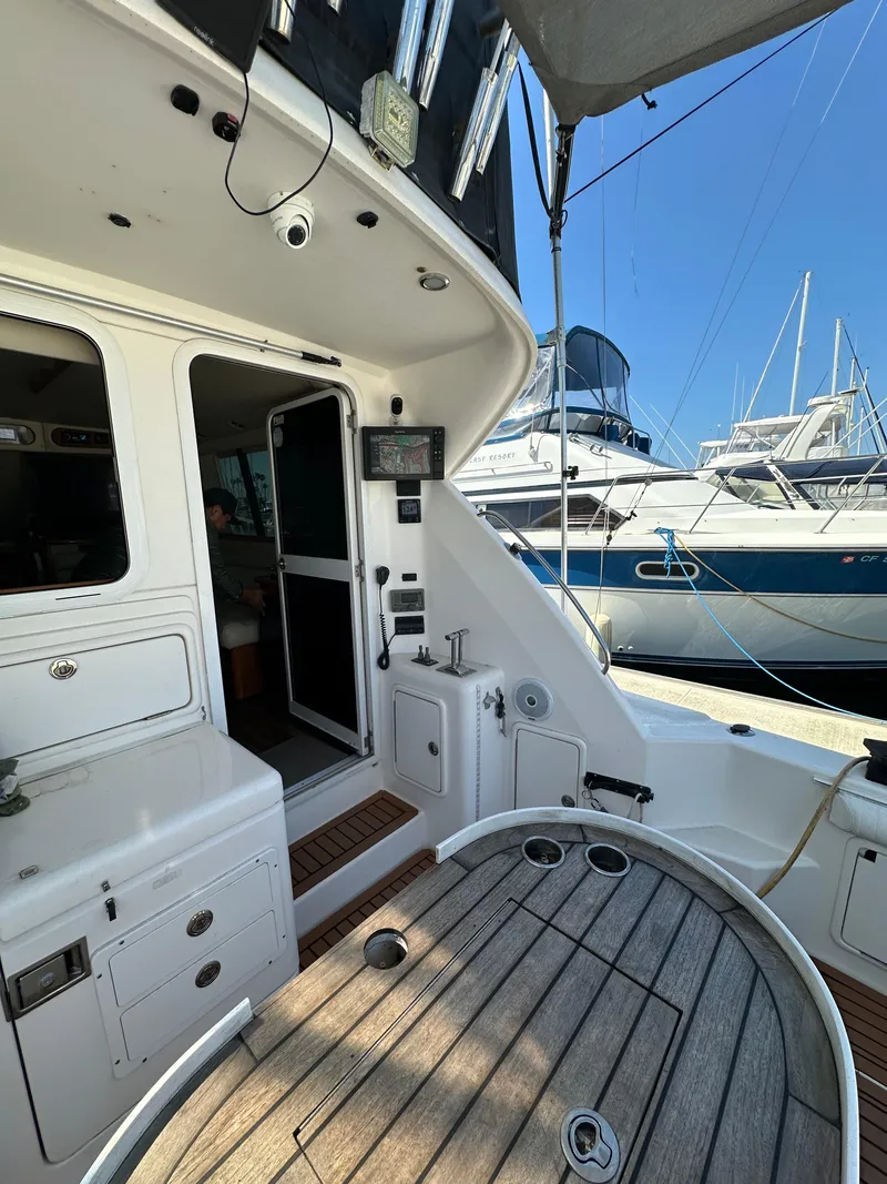 Slide: The Image of 2003 Riviera 37 Flybridge yacht interior with wooden deck and marina view. - 9