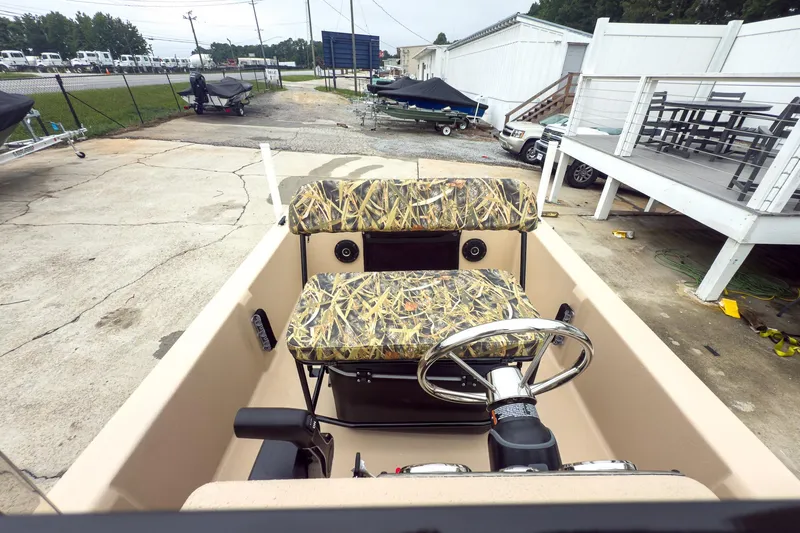 Slide: The Image of 2026 Carolina Skiff E20 JVX CC Sportsman boat with camo seats and steering wheel. - 11