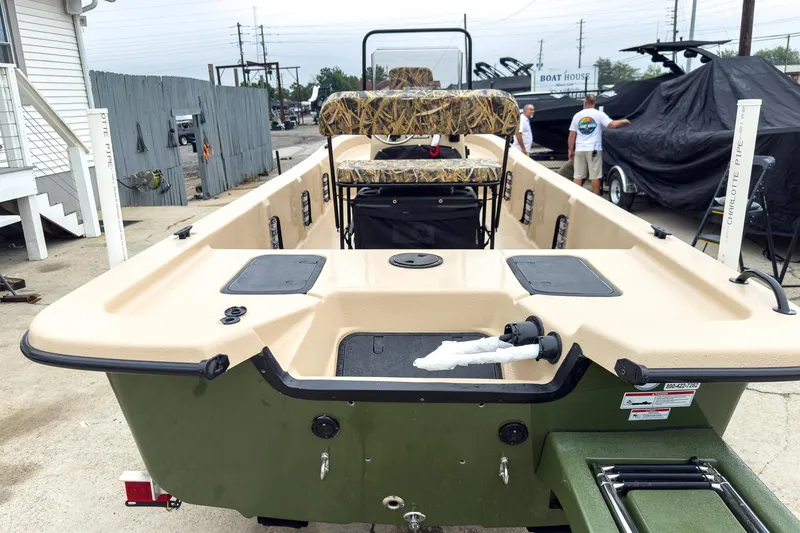 Slide: The Image of 2026 Carolina Skiff E20 JVX CC Sportsman boat, beige and green, parked outdoors. - 13