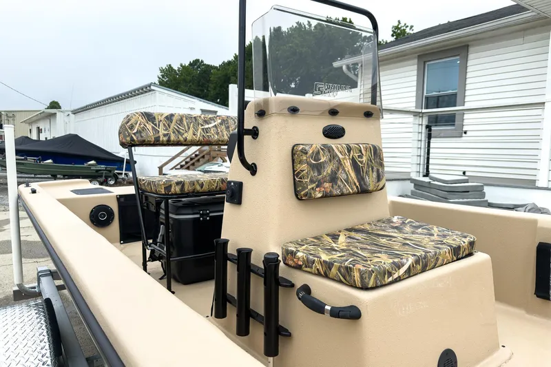 Slide: The Image of 2026 Carolina Skiff E20 JVX CC Sportsman boat with camo seating, docked outdoors. - 3