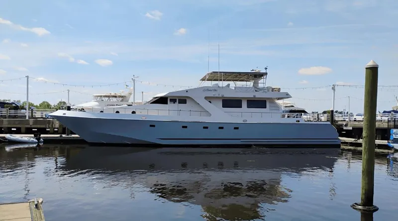 The Image of Custom New York Yachts 88, 1991 model, docked at a marina on a sunny day. - 1