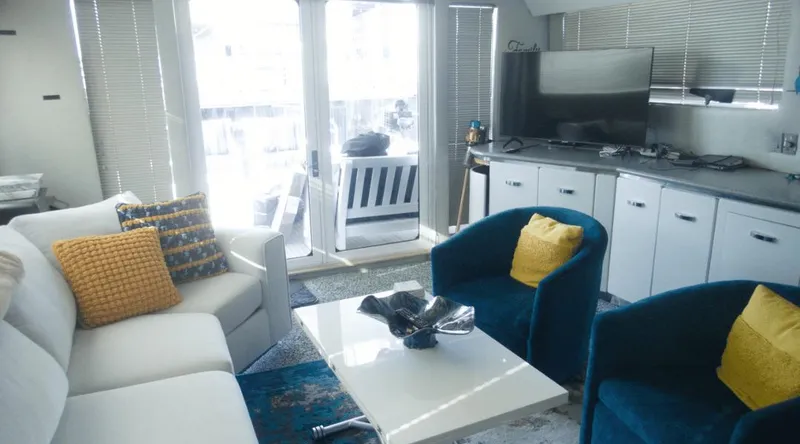 Slide: The Image of Luxurious yacht interior with modern decor, featuring blue and yellow accents, and a sleek entertainment area. - 23