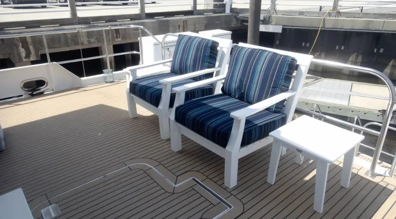 Slide: The Image of Deck seating on 1991 Custom New York Yachts 88 with striped cushions and table. - 32