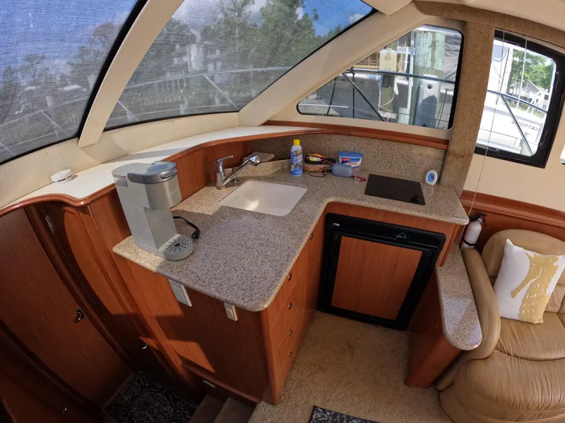 Slide: The Image of 2008 Silverton 33 Convertible yacht interior with kitchenette, featuring sink, countertop, and appliances. - 12